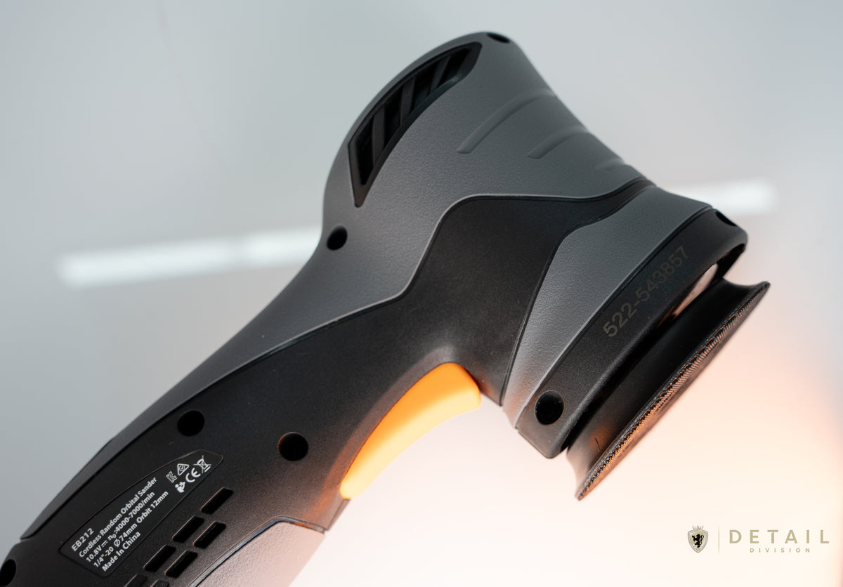 Car detailing tool with glowing orange light on a blurred background