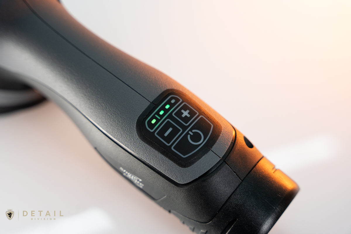 Close-up of a polishing tool with control buttons and LED lights on a blurred background